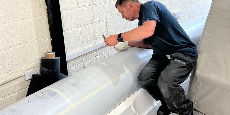 Ribcollar technician using a bespoke Hypalon sanding machine to prepare RIB tube fabric for bonding