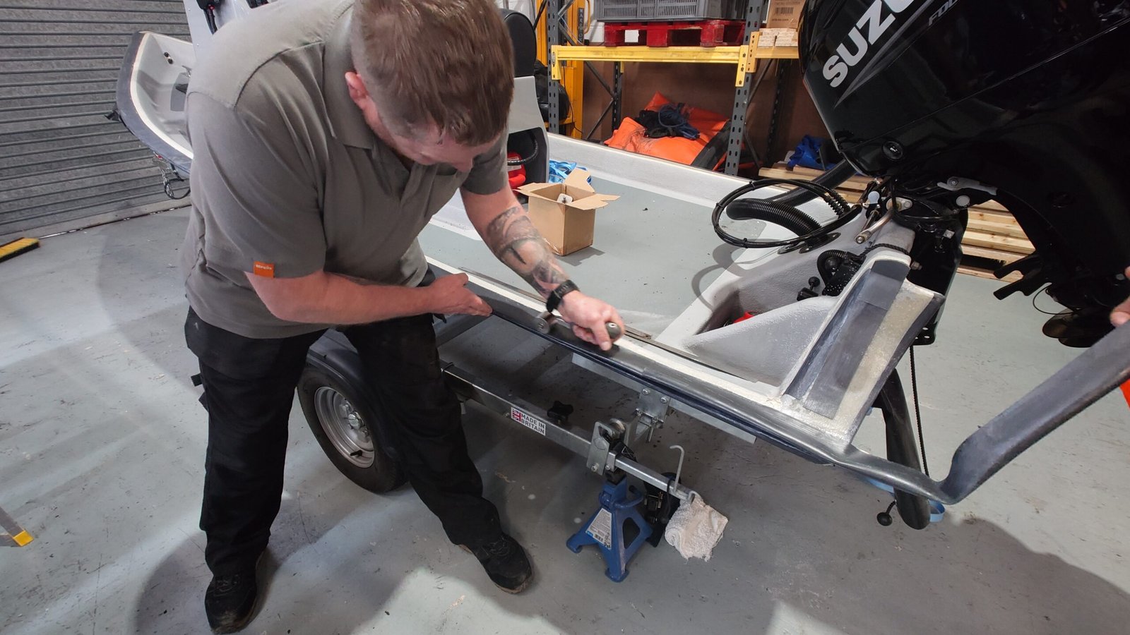 Technician preparing a RIB hull flange for Hypalon collar attachment at Ribcollar