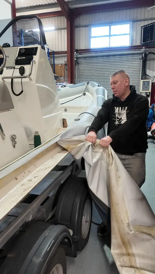 Technician preparing a RIB hull flange for Hypalon collar attachment at Ribcollar